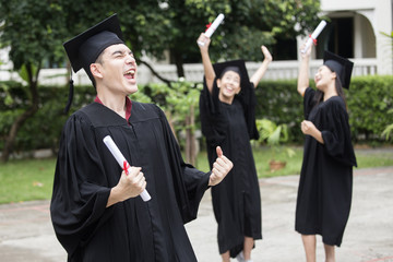 Young Asian Man Students wearing Graduation hat and gown at University, Man Students  with Graduation Concept.