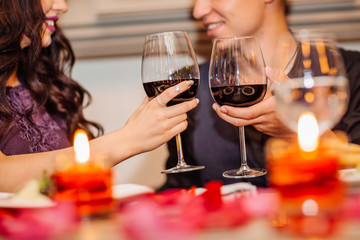 young and happy couple enjoying a glass of wine in sitting at a table  in the restaurant
