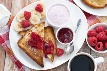 sweet toasts with fresh raspberry, jam and yoghurt for breakfast, top view