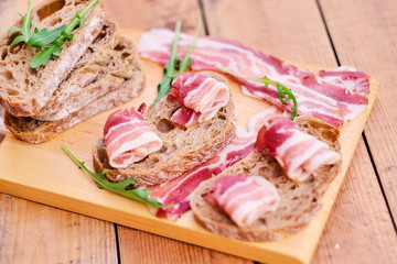 Bread with gourmet meat on a wooden desk.