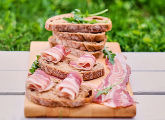 Bread with gourmet meat on a wooden desk.