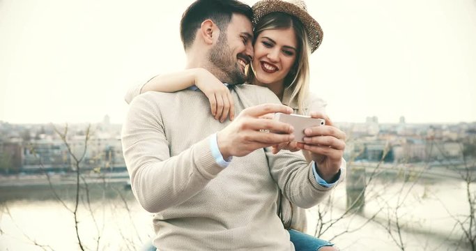 Beautiful couple taking selfies and smiling while traveling