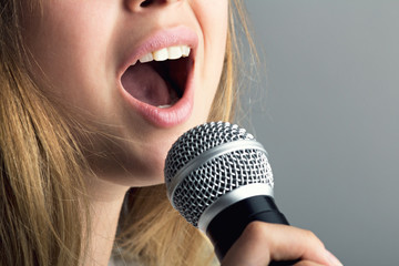 Close-up of a mouth of a woman singing into a microphone