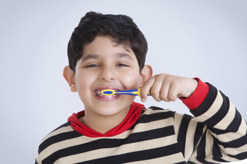 Portrait of little boy brushing his teeth