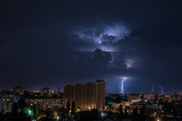 Яркая молния на ночном небе над городом