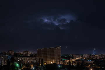 Яркая молния на ночном небе над городом