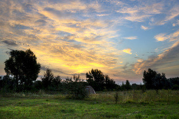 Naklejka na ściany i meble Beautiful sunrise in a field with amazing clouds. Tent. Travels.