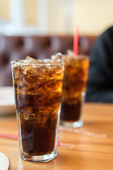 Double soft drink carbonated fresh food soda, white dish on wooden table with handsome man sitting  brown sofa in pizzeria restaurant