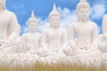 White Buddha statues on blue sky background