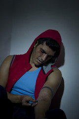 Young man injecting drugs on arm