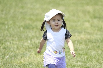 芝生の上を走る幼児(2歳児)