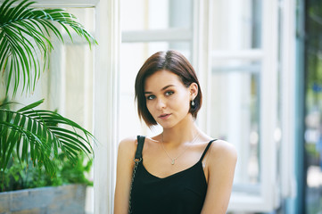 Portrait of young beautiful woman with a short haircut in the city