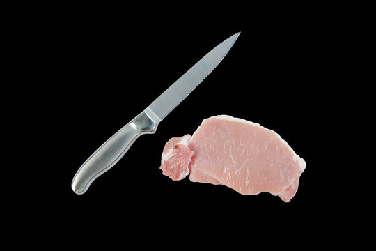 Knife and Chopped raw pork tenderloin isolated on black background.