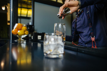 Bartender is making cocktail at bar.