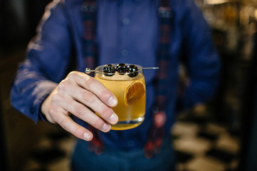 Bartender is making cocktail at bar.