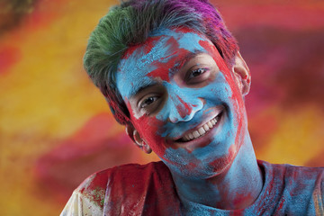 Man's face covered in holi colours 