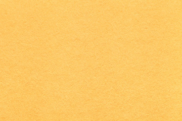 Texture of old light yellow paper background, closeup. Structure of dense lemon cardboard