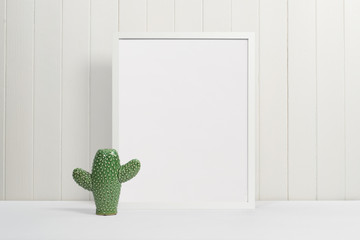 White picture frame with green ceramic cactus