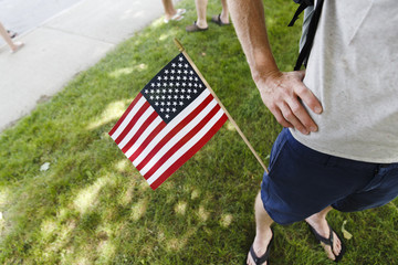 USA, Maine. American stars and stripes flag stick out of the pocket of the shorts of a man on the 4th of july.