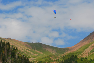 Fototapeta na wymiar Paraglider flying over mountains, Kazakhstan, Almaty, Medeo, Chymbulak