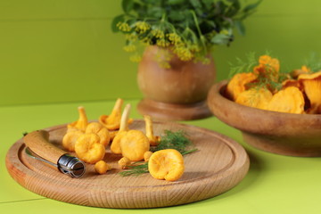 Fresh chanterelles are on a green wooden background.