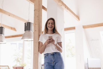 Young woman at home using smartphone