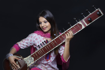 Obraz premium Young woman playing the sitar