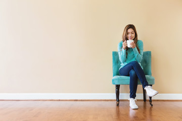 Young latina woman drinking coffee while sitting