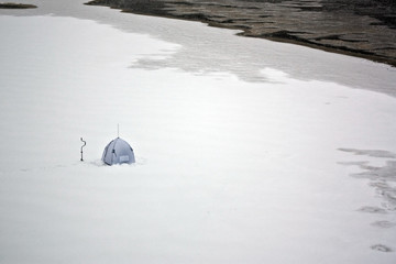 Lonely fisherman tent on ice