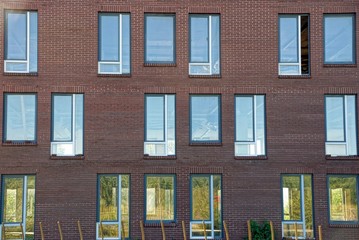 много окон на коричневой кирпичной стене здания