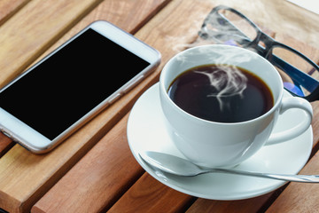 Coffee espresso cup hot  on a hardwood table,With book and smart phone