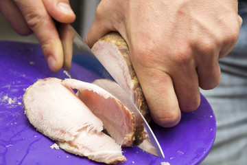 Man cutting smoked pork ham