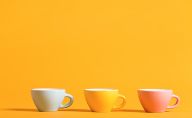 Little teacups aligned on a bright background