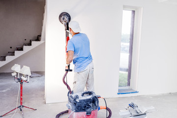 Worker polishes the wall. Plaster finishing float 