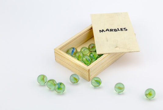 Wood Box Of Green Glass Marbles On White Background