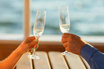 Happy couple drinks champagne on a yacht