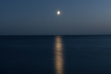 At night a white moon over the sea with a reflection and a path з