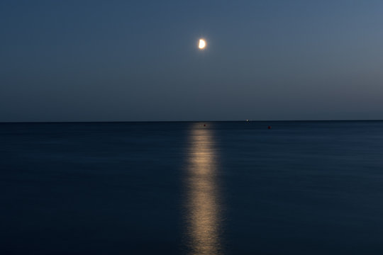 At night a white moon over the sea with a reflection and a path з