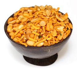 Mixture / Indian spicy snack mix served in coconut shell bowl on white background
