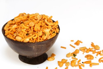 Mixture / Indian spicy snack mix served in coconut shell bowl on white background
