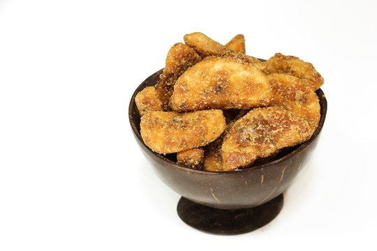 Sharkara Varetti served in coconut shell bowl on white background