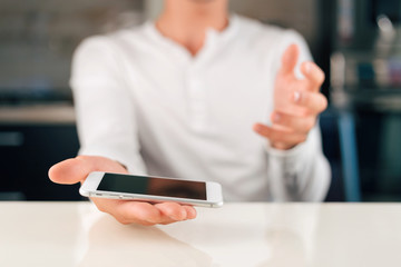 Man is holding white smartphone