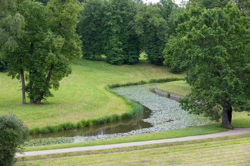 Fototapeta na wymiar Curved canal in the park, view from the hill