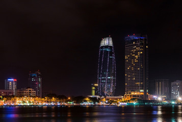 Fototapeta na wymiar Night view of modern buildings and Han River in Danang city