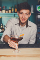 Bartender offers alcoholic cocktail in bar