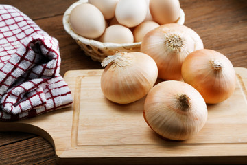 Still life with onions and quail eggs on a kitchen table