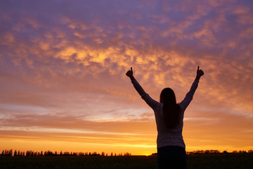Fototapeta na wymiar Silhouette of a girl enjoying sunset
