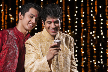 Men reading sms on mobile phone