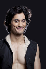 Portrait of smiling young man against black background 