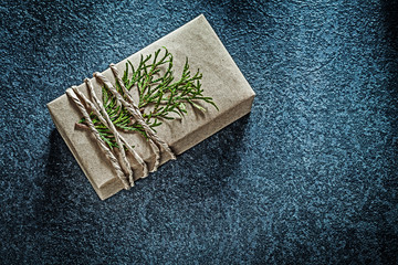 Wrapped present box with thuya branch on black background holida